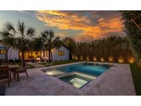 Inviting backyard with a sparkling pool, manicured lawn, lush privacy landscaping and a cozy fire pit area, perfect for relaxation at 1 Riverdale Dr, Charleston, SC 29407