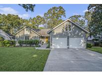 Charming home featuring a two-car garage, well-manicured lawn, and inviting curb appeal at 1141 Ambling Way, Mount Pleasant, SC 29464