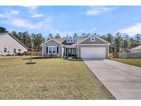 Charming single-Gathering home with a well-manicured lawn and a two-car attached garage at 1144 Wading Point Blvd, Huger, SC 29450