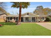 Charming single-story home featuring a brick facade, covered porch, and well-manicured lawn with a palm tree at 121 Milton Dr, Goose Creek, SC 29445