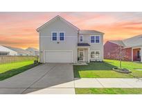 Charming two-story home with a well-manicured lawn and inviting curb appeal against a beautiful sunset backdrop at 142 Lucca Dr, Summerville, SC 29486