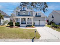 Charming two-story home boasts a welcoming front porch, manicured lawn, and two-car garage at 1704 Tolbert Way, Mount Pleasant, SC 29466