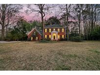 Charming two-story brick home featuring a covered front porch with white columns and a beautifully manicured lawn at 235 Scalybark Rd, Summerville, SC 29485