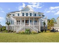 Elegant two-story home boasting a covered front porch, white railing, and beautifully landscaped yard at 2912 Yachtsman Dr, Mount Pleasant, SC 29466