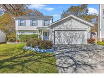 Charming two-story home featuring a well-manicured lawn, two car garage, and delightful curb appeal at 303 Axeminster Ct, Goose Creek, SC 29445