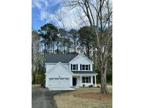 Charming two-story home featuring a gray roof, black shutters, and a welcoming front porch in a wooded location at 312 Woodland Shores Rd, Charleston, SC 29412