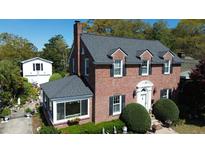 Charming brick home featuring a new roof, manicured landscaping, and an inviting sunroom at 4 Chadwick Dr, Charleston, SC 29407