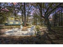 Relaxing fire pit area with Adirondack chairs and a view of the home's exterior at dusk at 5208 Holly Forest, Hollywood, SC 29449