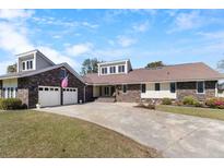 Charming brick home with two-car garage, well-manicured lawn, and a spacious driveway at 5286 Waterview Dr, North Charleston, SC 29418