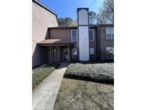 Two-story home with a brown exterior, a gray trimmed door and a tall white chimney on the side at 7945 Edgebrook Cir # B, North Charleston, SC 29418