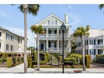 Beautiful three-story home with balconies, palm trees, and manicured landscaping at 106 Murray Blvd, Charleston, SC 29401