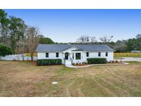 Charming white brick home featuring a metal roof and well-manicured landscaping at 1158 Wildgame Rd, Summerville, SC 29486
