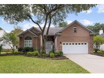 Charming brick home with mature trees, manicured landscaping, and an attached two-car garage at 1232 Palmetto Peninsula Dr, Mount Pleasant, SC 29464