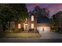 Charming brick home featuring a well-manicured lawn and two-car garage at dusk at 1324 Southlake Dr, Mount Pleasant, SC 29464