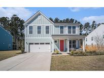Charming two-story home with light blue siding, white trim, and a bright red front door at 1427 Homecoming Blvd, Ravenel, SC 29470