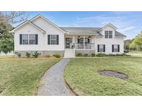 Charming two-story home with a manicured lawn and inviting front porch at 1493 Battery Reynolds Ct, Charleston, SC 29412