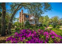 Charming brick home featuring a inviting front yard with blooming azaleas at 1521 Hurtes Island Dr, Charleston, SC 29407