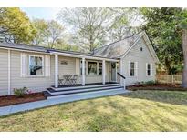 Charming home featuring a cozy front porch with seating and manicured landscaping at 1706 W Avalon Cir, Charleston, SC 29407