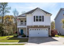 Charming two-story home featuring a stone facade, a blue front door, and an attached two-car garage at 1826 Towne St, Johns Island, SC 29455