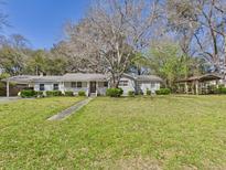 Charming single-story home with a covered porch and mature trees in a spacious front yard at 1876 Chilhowee Dr, Johns Island, SC 29455