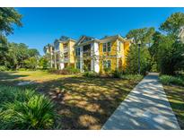 Beautiful yellow apartment building with a manicured lawn and a sidewalk leading to the entrance at 1928 Chatelain Way, Mount Pleasant, SC 29464