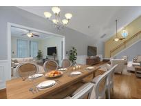 Bright dining room featuring hardwood floors and an elegant chandelier, flowing to the living room at 215 Angora Way, Summerville, SC 29485