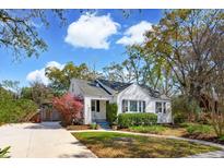 Charming single-story home with a manicured lawn, mature landscaping, and a paved driveway under a blue sky at 4 St Teresa Dr, Charleston, SC 29407