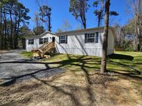 Well-maintained single story home featuring vinyl siding, blue shutters, and a newly constructed front porch at 4532 S Carolina # 41, Huger, SC 29450