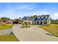Beautiful two-story home with a circular driveway and detached garage and carport at 614 Cummings Chapel Rd, Ridgeville, SC 29472