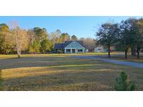 Charming craftsman-style home featuring a spacious lawn, mature trees, and a detached shed at 10044 Randall Rd, McClellanville, SC 29458