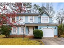 Charming two-story home with light blue siding, white trim, attached garage, and landscaped front yard at 102 Kingsbridge Dr, Goose Creek, SC 29445