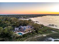 Expansive waterfront estate features a private dock, luxurious pool, and lush landscaping, creating an idyllic coastal retreat at 108 Salthouse Ln, Kiawah Island, SC 29455