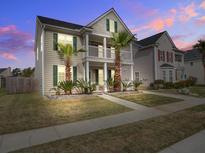Charming two-story home with a balcony, palm trees and manicured lawn, perfect for relaxed living at 125 Old Jackson Rd, Goose Creek, SC 29445