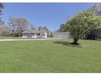 Charming home with large front yard, mature trees, and a detached three-car garage on a sunny day at 1298 French Santee Rd, Jamestown, SC 29453