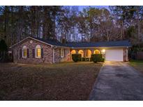 Charming brick home featuring an arched porch, attached garage, and a well-manicured front yard at 185 Foxborough Rd, Goose Creek, SC 29445