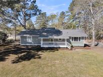 Charming one story home with white picket fence porch and natural landscaping at 212 Lake Moultrie Dr, Bonneau, SC 29431