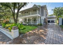 Charming two-story home featuring a brick driveway, a large front yard, and double covered porches at 2142 Golfview Dr, Charleston, SC 29412