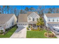 Charming two-story home with a well-manicured lawn and a welcoming front porch in a suburban neighborhood at 311 Weston Hall Dr, Summerville, SC 29483