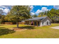 Charming home with a metal roof, welcoming front porch, and a spacious, well-manicured lawn at 508 Horse Trail Rd, Saint George, SC 29477