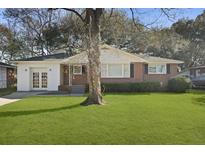Charming home featuring a well-maintained front lawn, a tree, and a brick and white exterior at 5314 Albert St, North Charleston, SC 29418