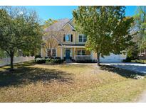 Charming two-story home with a well-manicured lawn, mature trees, and an inviting front porch at 1067 Shipton Ct, Charleston, SC 29414