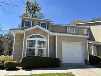 Charming tan home with an attached garage and neatly trimmed front yard at 111 Spanish Oak Ln, Ladson, SC 29456