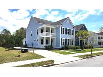 Charming two-story home with double porches, light blue siding, black shutters and a well manicured lawn at 1984 Shadetree Blvd, Johns Island, SC 29455