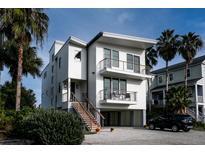 Modern three-story home with white siding, black trim, multi-level balconies, and a well-kept yard at 3803 B Scott Creek Dr, Edisto Beach, SC 29438
