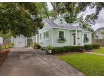 Charming home featuring a lush green lawn, driveway, and well-manicured landscaping with a light green exterior at 4804 Parkside Dr, North Charleston, SC 29405