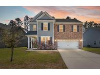 Charming two-story home with brick and siding, offering a well-manicured lawn and inviting curb appeal at 686 Redbud Ln, Summerville, SC 29486