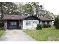 Charming one-story home featuring mature trees, a well-kept lawn, and a concrete driveway at 790 Hoss Rd, Charleston, SC 29414