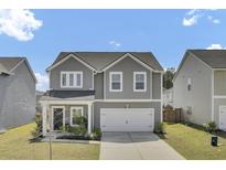 Charming two-story home boasts a well-manicured lawn and a two car garage at 85 Arrowwood Way, Summerville, SC 29485