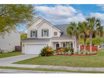 Charming two-story home featuring a manicured lawn, palm trees and an attached two-car garage at 9400 Divot Ln, Summerville, SC 29485