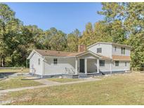 Charming two-story home with a covered front porch surrounded by lush greenery at 117 Wernham Ln, Moncks Corner, SC 29461